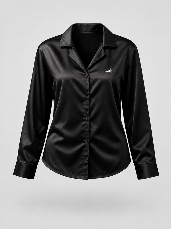A black satin long-sleeve button-up shirt with a small white embroidered logo on the left chest, displayed on a neutral light gray background.