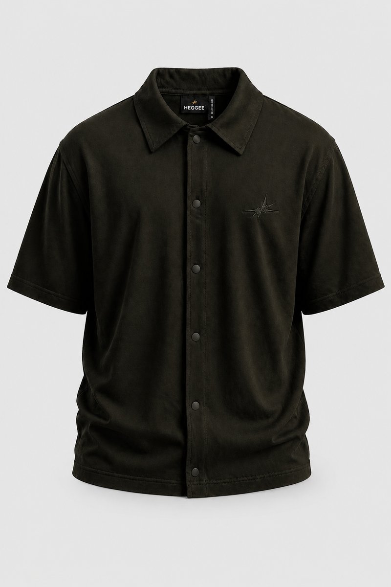 A dark olive green short-sleeve button-up shirt by, 'HEGGEE' featuring a classic collar, snap-button front, and a small embroidered logo on the left chest, displayed on a neutral light gray background.
