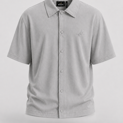 A light gray short-sleeve button-up shirt with a pointed collar and a small embroidered logo on the left chest, displayed on a neutral light gray background.