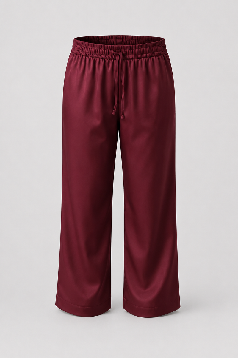 A pair of wide-leg cropped pants in a deep burgundy color, featuring an elastic waistband and a drawstring, shown against a light gray background.