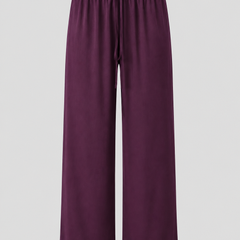 A pair of wide-leg lounge pants in a deep plum purple color, featuring an elastic waistband and drawstring, shown against a neutral light gray background.