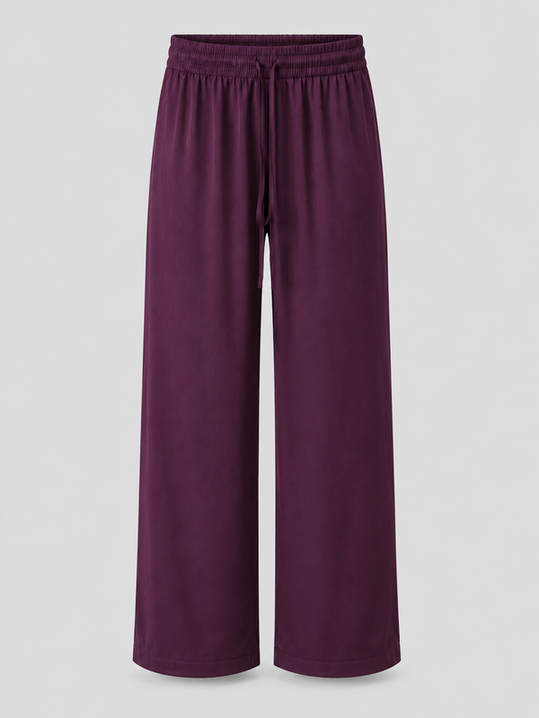A pair of wide-leg lounge pants in a deep plum purple color, featuring an elastic waistband and drawstring, shown against a neutral light gray background.