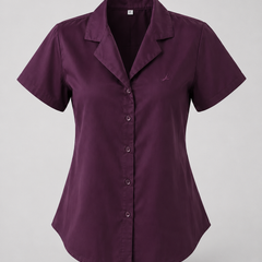A short-sleeve button-up shirt in deep plum purple, featuring a notched lapel collar and a small embroidered logo on the left chest, displayed on a neutral gray background.