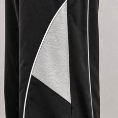 Black and gray athletic pants with a geometric design on a light gray background