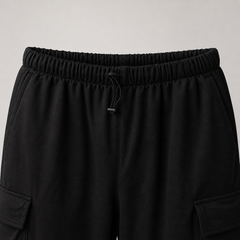 Black cargo pants with an elastic waistband on a light gray background