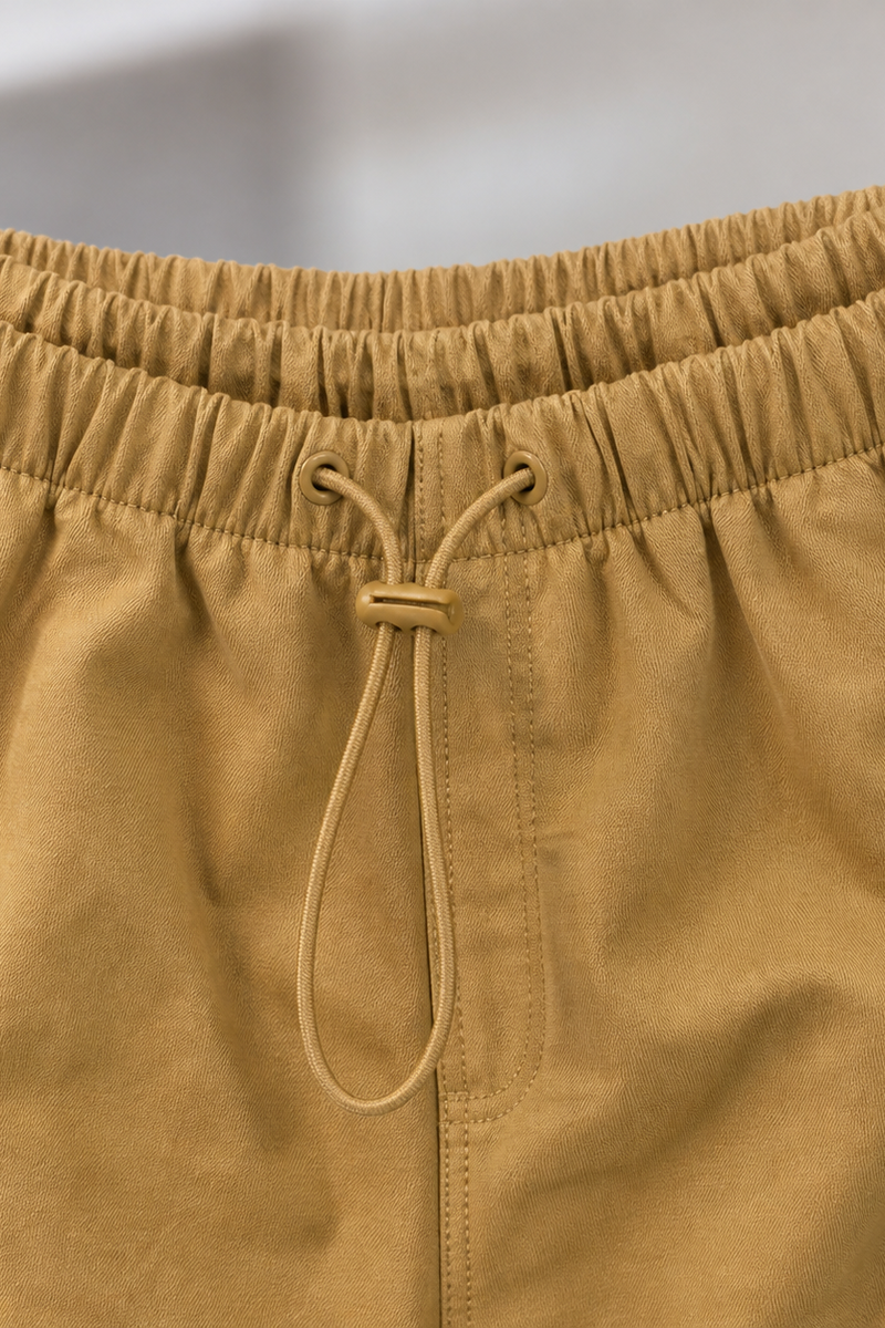Close-up of Mustard yellow pants with a drawstring on a blurred background