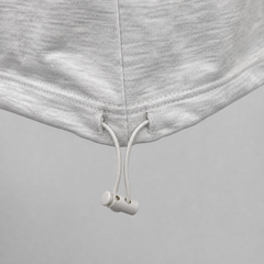 Close-up of gray sweatpants with white drawstrings on a gray background