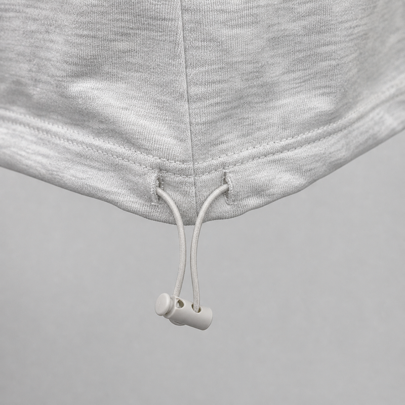 Close-up of gray sweatpants with white drawstrings on a gray background