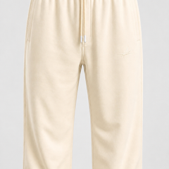 Cream-colored fleece sweatpants with an elastic waistband, drawstring, and a small embroidered logo on the left thigh, shown against a light gray background.