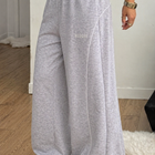 Gray wide-leg pants with 'Heggee' text worn by a person indoors.