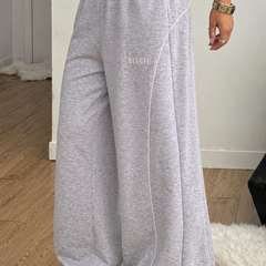 Gray wide-leg pants with 'Heggee' text worn by a person indoors.