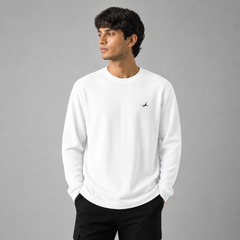 Person wearing a white sweatshirt with a small logo on a gray background