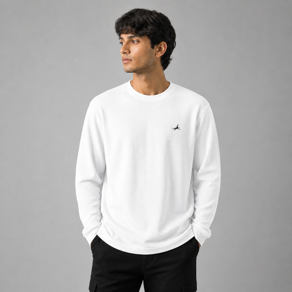 Person wearing a white sweatshirt with a small logo on a gray background