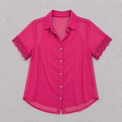 Pink blouse with lace trim on a gray background