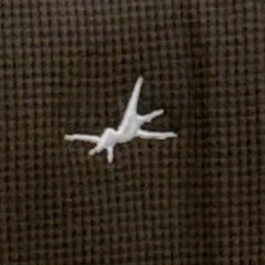 Small white object on a brown textured fabric background