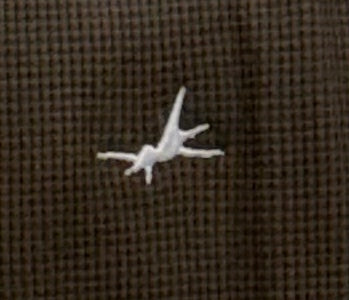 Small white object on a brown textured fabric background