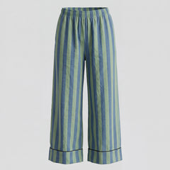 Striped pants with blue and green vertical stripes on a light gray background