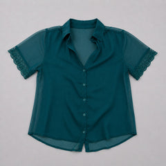 Teal blouse with lace sleeves on a light gray background