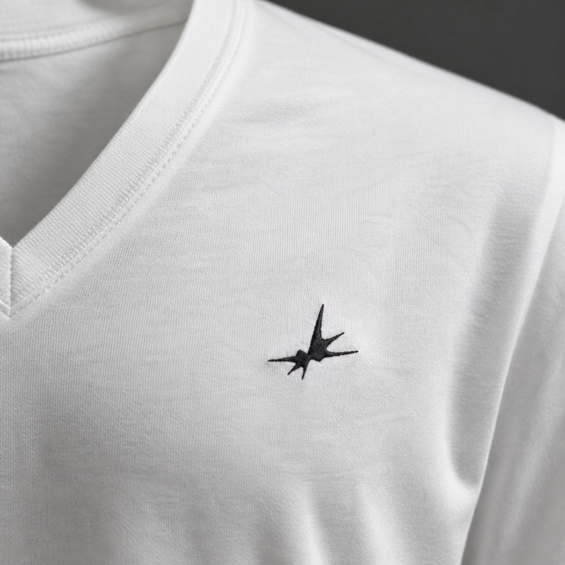 White shirt with a black embroidered star design on a dark background