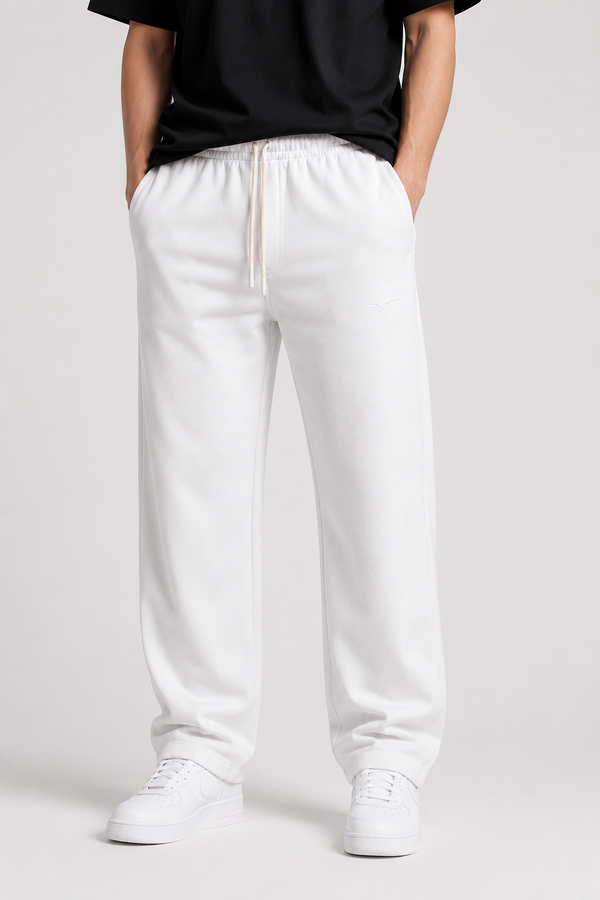White sweatpants with a drawstring waist, modeled with a black t-shirt and white sneakers against a light gray studio background.