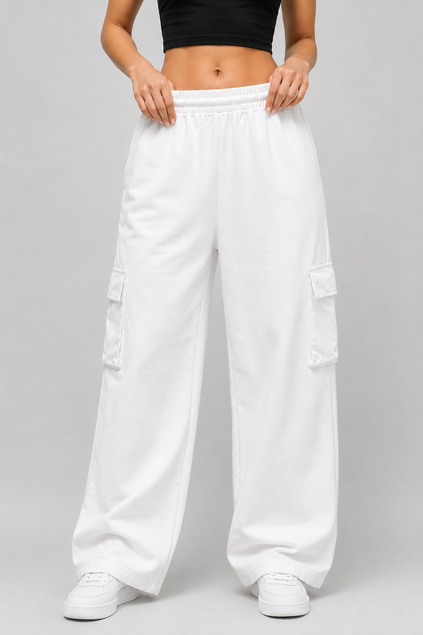 White wide-leg cargo pants with an elastic waistband, modelled with a black crop top and white sneakers against a light gray studio background.