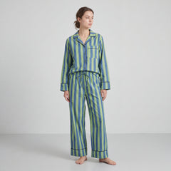 Woman wearing a blue and green striped pajama set on a white background