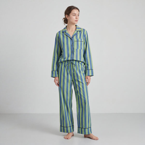 Woman wearing a blue and green striped pajama set on a white background