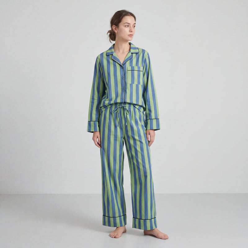 Woman wearing a blue and green striped pajama set on a white background